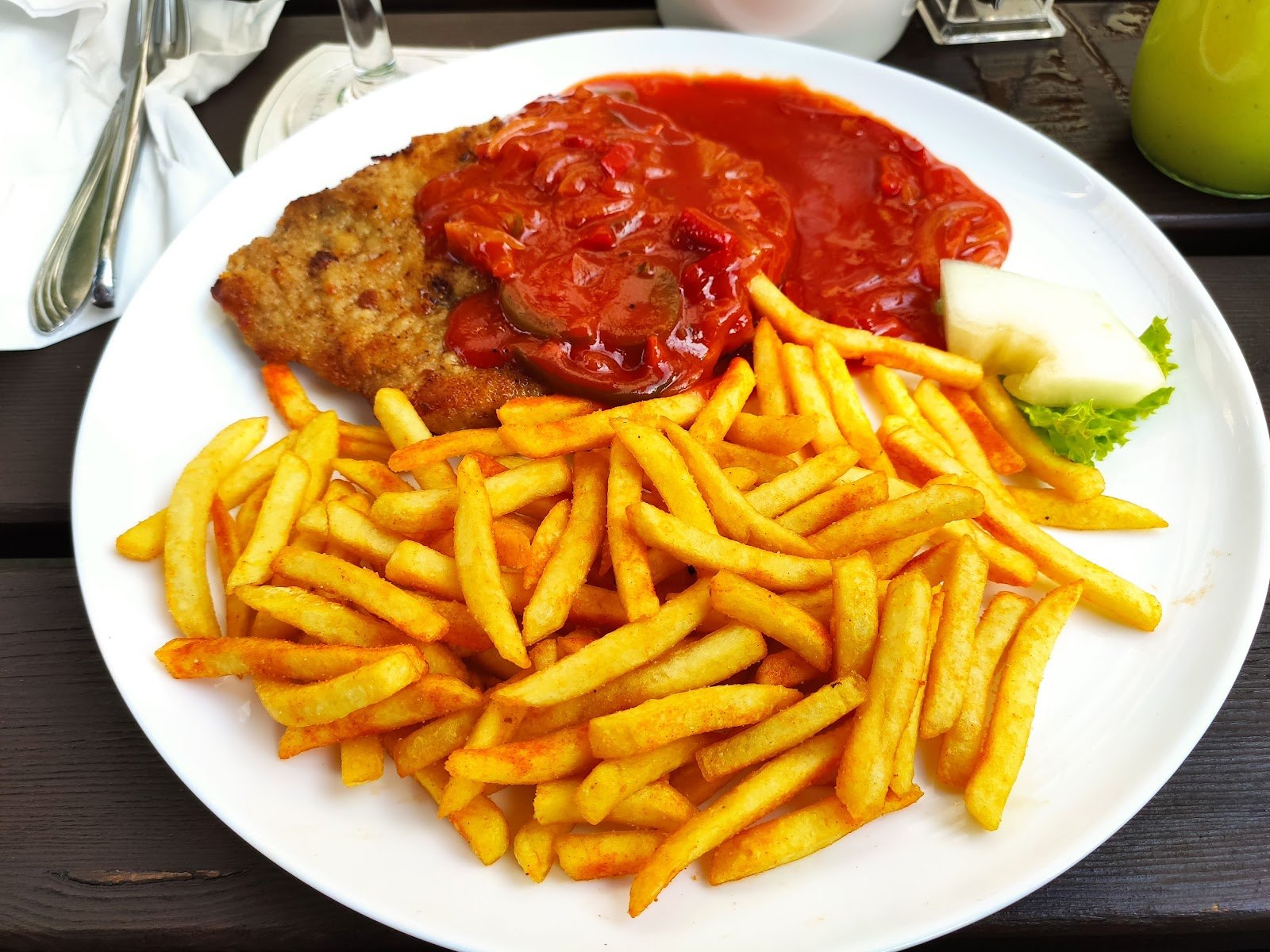 Paniertes Schnitzel mit Tomaten-Paprika-Soße und Pommes